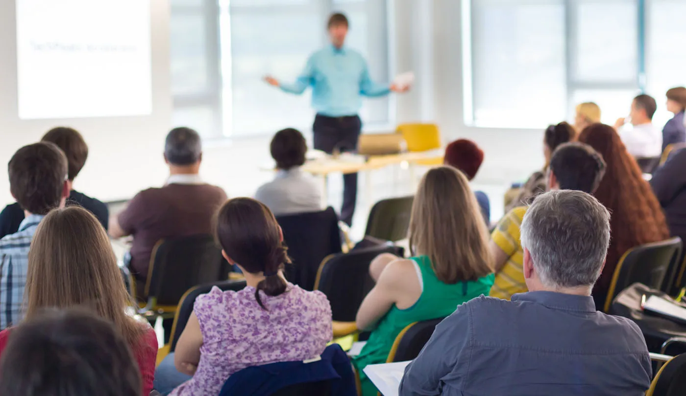 Eine Gruppe sitzender Menschen lauscht einem Vortrag.