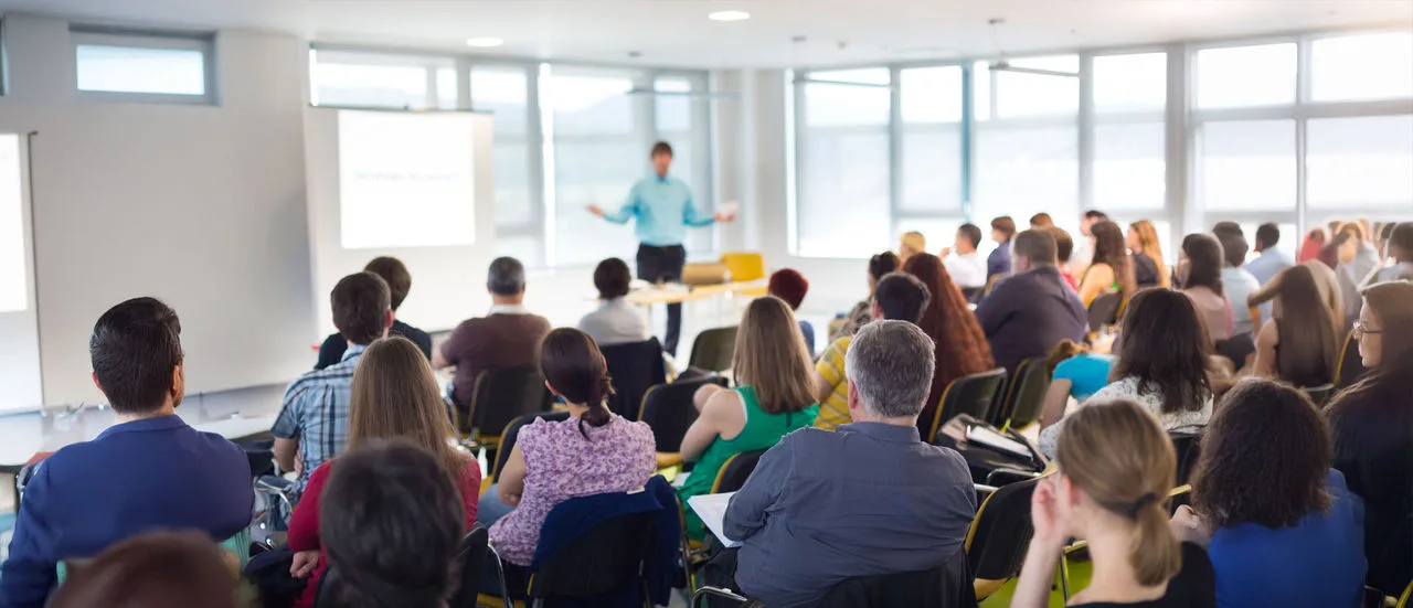 Eine Gruppe sitzender Menschen lauscht einem Vortrag.